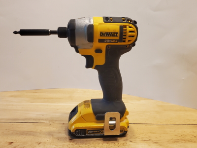 Dewalt Impact Driver on a wooden table with white backdrop